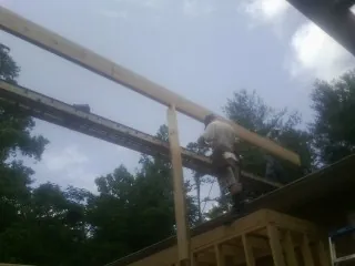Carpenter setting a ridge beam over a new addition frame — Ice Dam Removal by Roofing Brothers in Mountainville