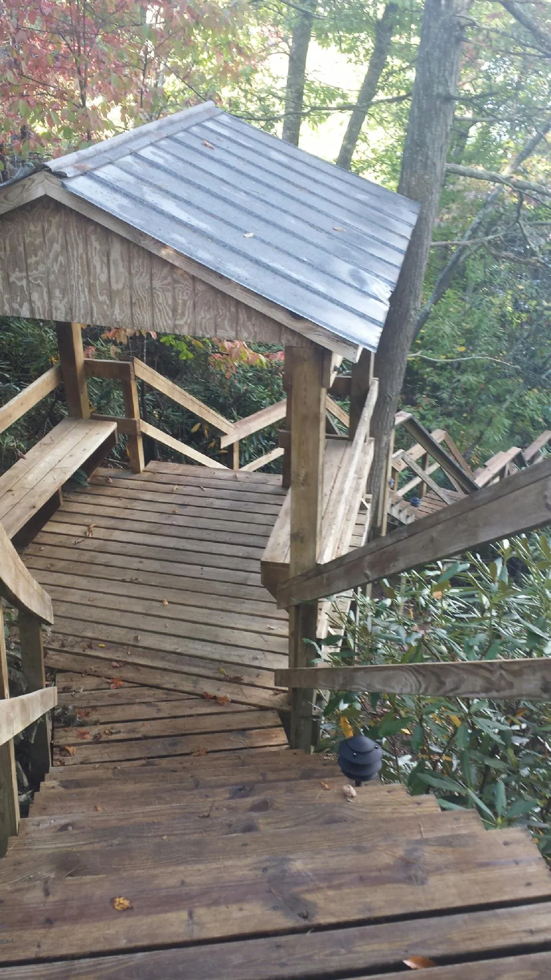 Metal roofed shelter over wooden steps on a wooded walkway — Skylight Repair & Installation work by our crew in Mountainville