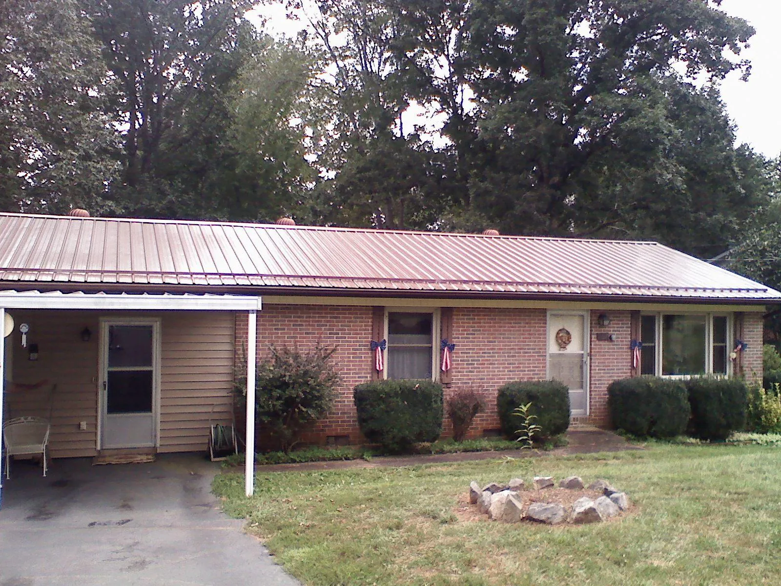 Bronze metal roof and carport on a brick ranch home — Roof Repair work by our crew in Mountainville