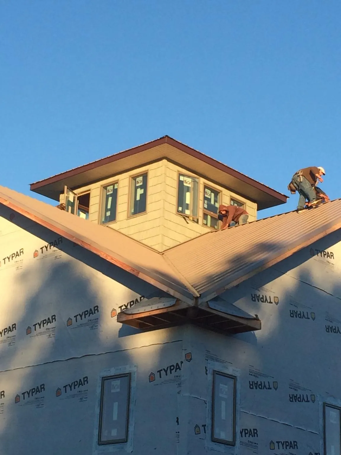 Roofers working around a rooftop cupola on a new metal roof at sunset — Roof Waterproofing in Mountainville by Roofing Brothers